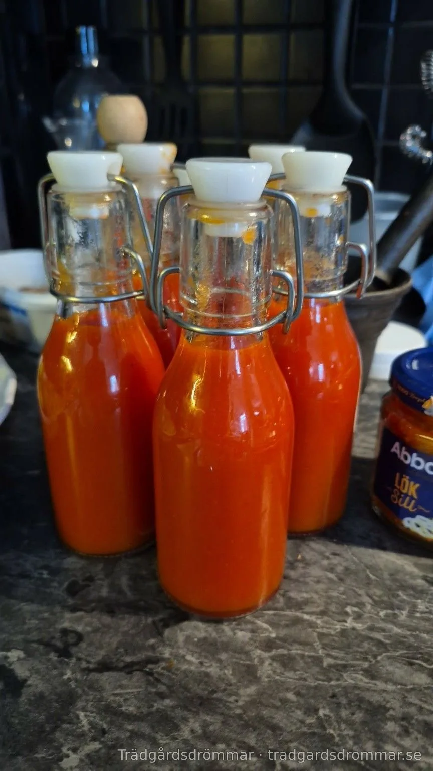 Flaskor med orangefärgad chilisås